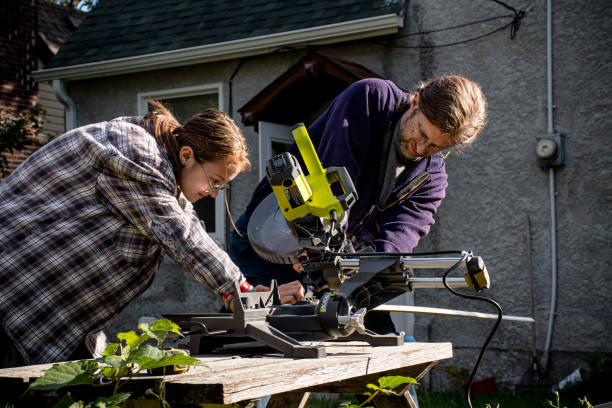 istock Father Teaching Trans Son to Use Miter Saw in Backyard Workshop 2187953263