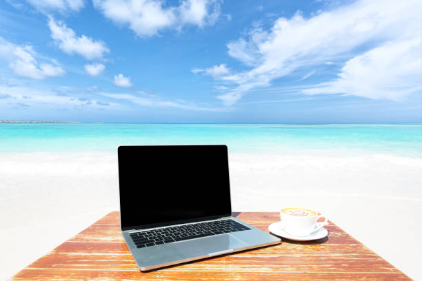 istock Mobile work office on the tropical beach with blank laptop screen 2187957577