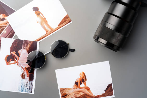 istock Photo camera with colorful printer photos on gray desk 2187966421