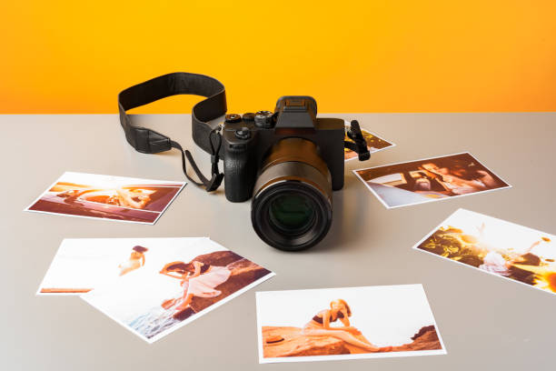 istock Photo camera with colorful printer photos on gray desk 2187967456