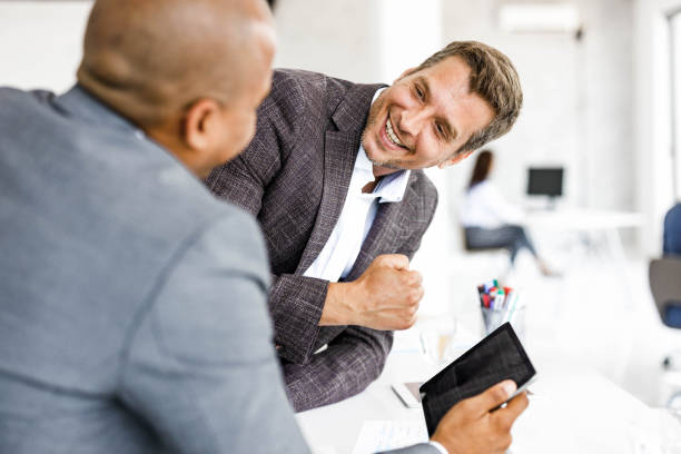 istock Happy male entrepreneurs talking while working on digital tablet in the office. 2187968443