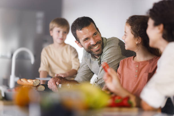 istock Happy family talking while making a meal in the kitchen. 2187968550