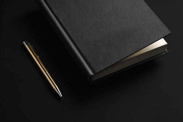 istock Black hardcover book or notepad mock up on black background 2187971182