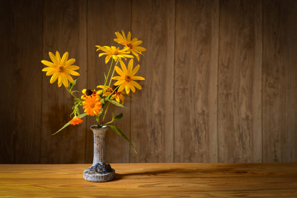 Still life, flowers in a ceramic vase, in the studio on a wooden table
