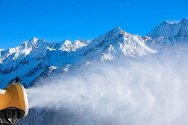 Snowmaking  with snow gun.  Ski slope artificial snowing. Ski resort  with snow cannon - snow making machine. Beautiful winter nature. Fresh snow on the top of  mountains.  High mountain landscape Dolomite Ski area. Italian Alps
