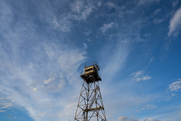 A communications tower full of a variety of antennas stands out against a deep, blue, clear sky background.