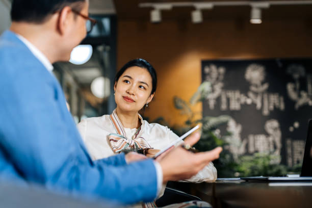 istock Asian business colleagues discussing documents on digital tebalet in a modern office. 2187976086