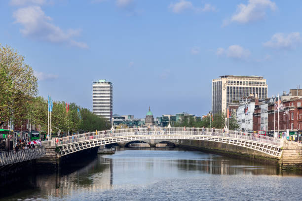 Dublin - Ireland. May 18, 2024: The iconic Ha'penny Bridge spans the River Liffey, connecting both sides of Dublin bustling city center