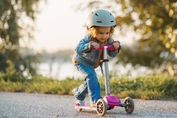 Girl driving push scooter in park