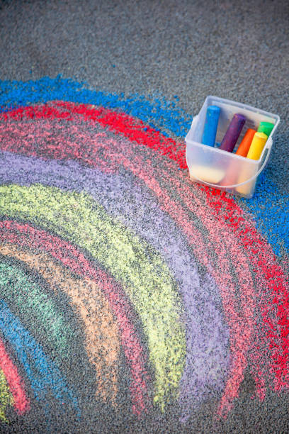 istock Sidewalk chalk drawing. A rainbow painted on the asphalt. Kids activities 2187979683