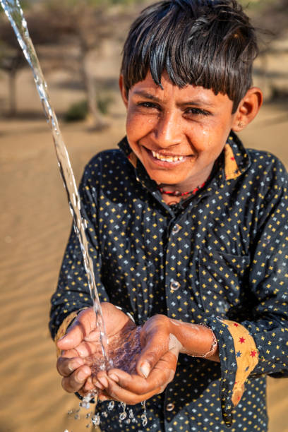 istock Indian young boy drinking fresh water, desert village, Rajasthan, India 2187980038