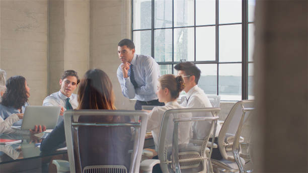 istock Business Team Meeting Sitting Around Table In Modern Office Discussing Documents 2187982428