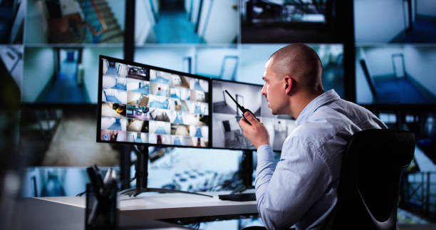 istock Security System Cctv Monitor Room. Man Using Walkie Talkie 2187983192
