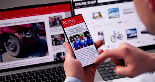 istock Watching Online News Article On Mobile Phone And Laptop 2187984550