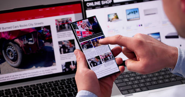 istock Watching Online News Article On Mobile Phone And Laptop 2187984640