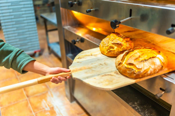 istock Man removing baked artisan bread from oven 2187987026