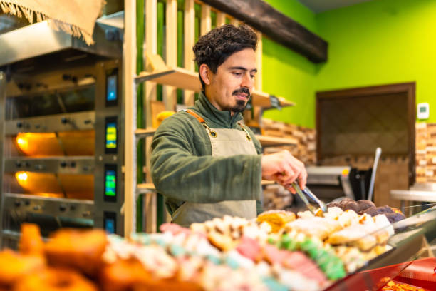 istock Baker arranging pastries on the counter of a shop 2187987103