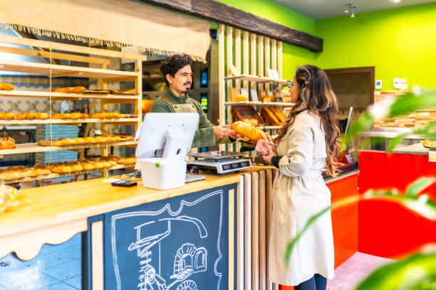 istock Salesman giving bread to a client in an artisan bakery 2187987132