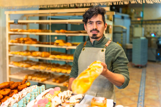 istock Baker offering baguette in a bakery shop 2187987241