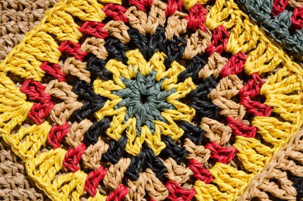 Raffia yarn texture. Granny square made of raffia in multicolored flowers. Eco-friendly material for handcraft.