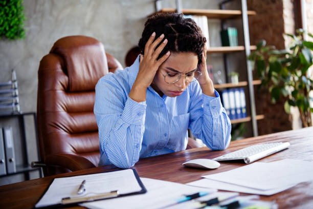 istock Stressed businesswoman sitting at office desk in contemporary workspace, facing work challenges 2187988286