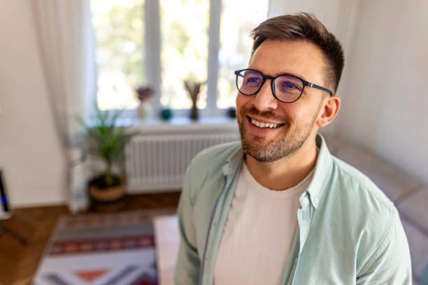 istock Happy Man With Glasses Smiling Inside a Bright Modern Apartment 2187988448