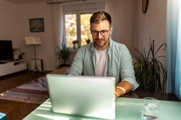 istock Man Working Remotely On Laptop In A Bright Home Office Environment 2187988460