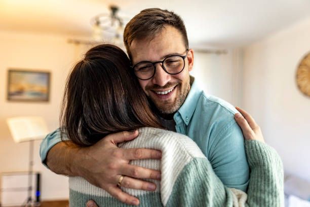 istock Warm Hug Between Two Friends in a Bright Living Room 2187988713