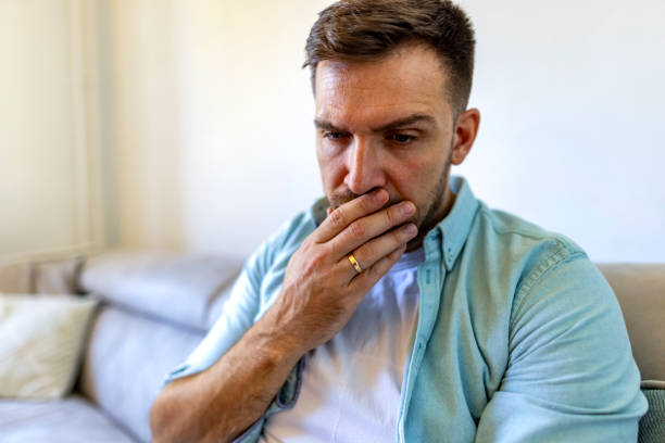 istock Pensive Man Sitting on Sofa in Contemplative Thought at Home 2187988871