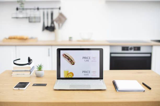 istock Laptop displaying fast food online sales site in modern kitchen 2187989137