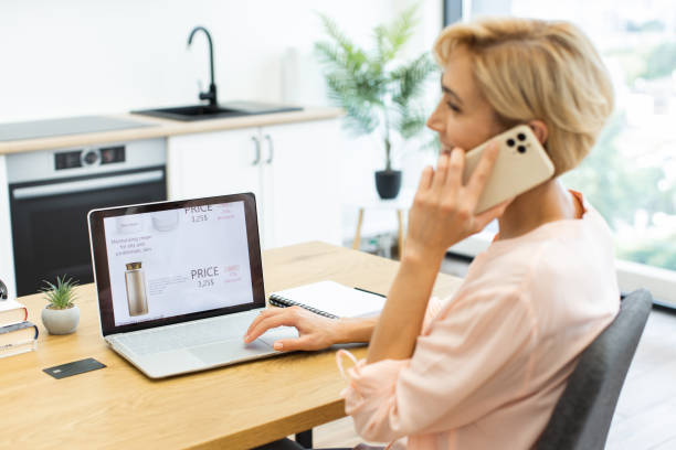 istock Caucasian woman shops cosmetics online while talking on phone 2187989182