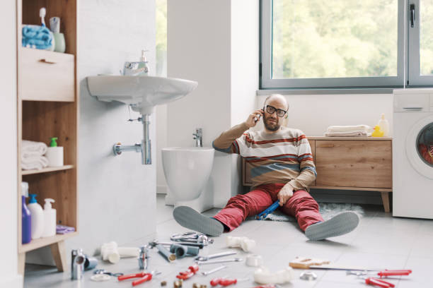 istock Frustrated man sitting on the floor and calling a plumber 2187991140
