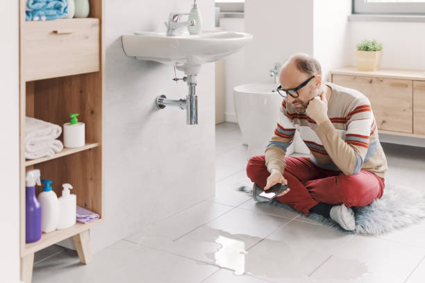 Sad man looking at a water leak