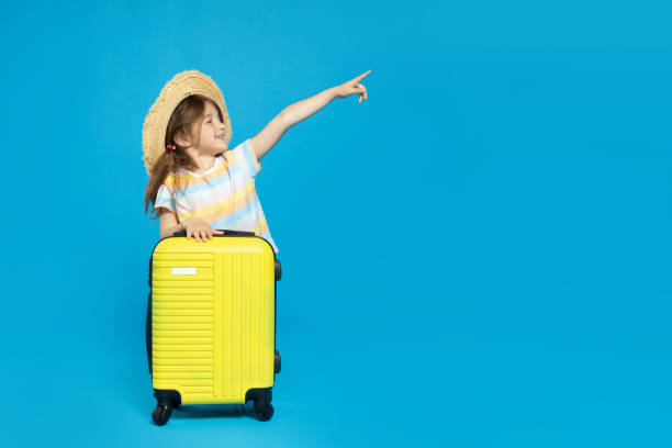istock A little girl in a beach hat with a suitcase 2187992655