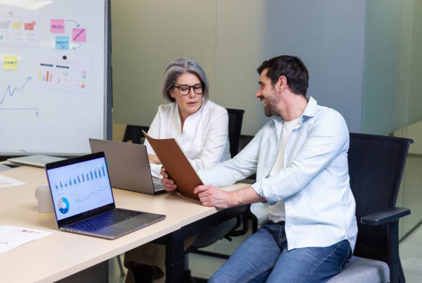 istock Business people working together in coworking space analyzing charts and reports 2187993612
