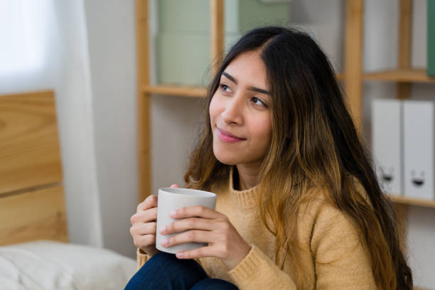 istock woman relaxing at home, drinking coffee and daydreaming 2187993686