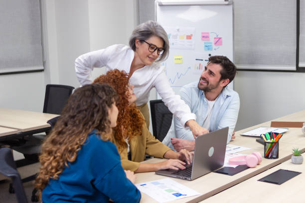 istock Coworkers collaborating on project using laptop in meeting room 2187995245