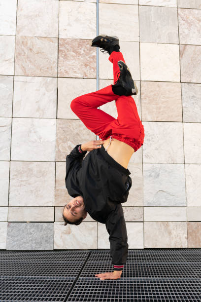 istock A young man in red pants performs a breakdance pose on a metal grate 2187995588