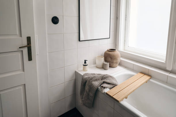 istock Elegant bathroom. Modern Scandinavian bathroom interior with bathtub. Black picture frame mockup. White tiles wall. Candle, towel, soap dispenser and old vase near window. Top view. 2187996639