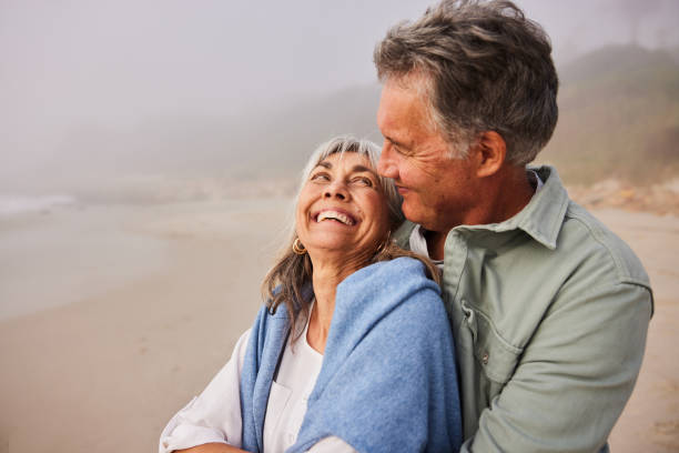 istock Senior couple embracing and smiling face to face on beach 2187998380
