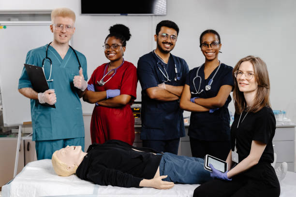 istock Group of doctors standing at the bed with mannequin at first aid training course 2188000459