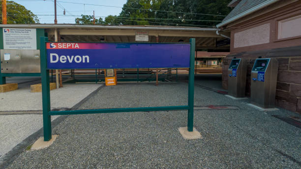 Wayne, Pennsylvania. USA - Ago 14th 2024: A sign for the Devon train station is on a grey concrete surface. The sign is blue and white