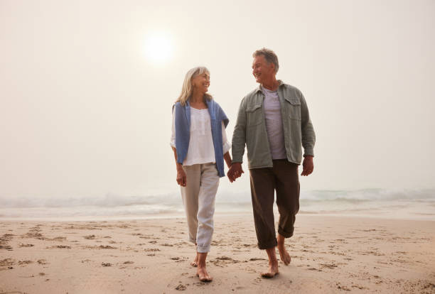 istock Affectionate senior couple walking on beach holding hands 2188002452