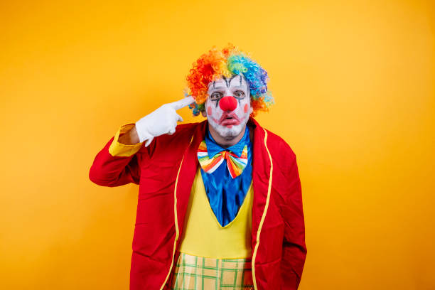 istock Smiling clown pointing, vibrant yellow background, fun. 2188006350