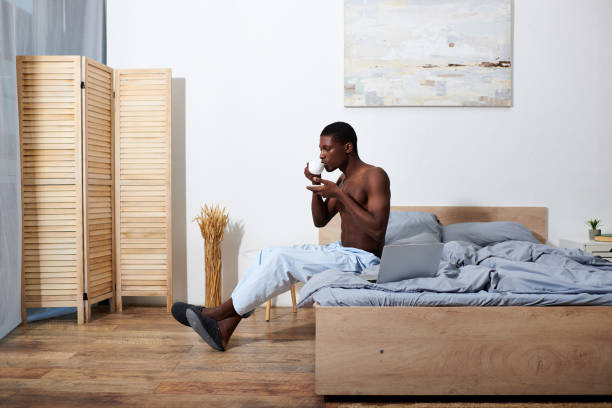 istock Young handsome man enjoying a quiet morning with tea in a cozy bedroom setting 2188011957