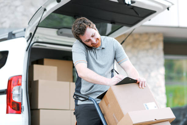 istock Professional delivery man having a phone call and signing delivery documents 2188013738