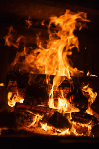 istock Bright flames and glowing embers consuming stacked firewood in a fireplace, vertical shot 2188013986