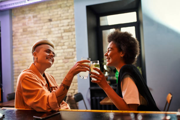 Young diverse couple enjoying drinks and laughter at a cozy cafe during an evening date