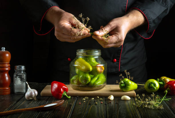 istock Hands skillfully prepare vibrant green and red peppers alongside garlic, blending fresh herbs in a glass jar. The cozy kitchen invites warm culinary creativity, celebrating home-cooked flavors 2188015903