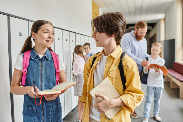istock Joyful interaction between teacher and students in a vibrant school hallway during class time 2188016075